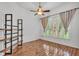 Light-filled bedroom featuring hardwood floors, plantation shutters, and a ceiling fan at 2202 Hickory Ridge Dr, Valrico, FL 33596
