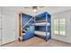 This bedroom showcases custom blue bunk beds, natural wood accents, and a bright window at 2202 Hickory Ridge Dr, Valrico, FL 33596