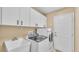 Functional laundry room with ample cabinet space, modern appliances, and a utility sink at 2202 Hickory Ridge Dr, Valrico, FL 33596