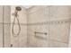 Updated shower featuring neutral tile, a shower head, and a convenient grab bar at 2202 Hickory Ridge Dr, Valrico, FL 33596