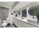 Modern bathroom with dual vanities, round mirrors, and stylish herringbone flooring at 2584 58Th S Ave, St Petersburg, FL 33710