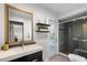 Modern bathroom features a sleek vanity, stylish mirror, and walk-in shower with glass doors and pebble floor at 2584 58Th S Ave, St Petersburg, FL 33710