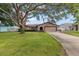 Charming single-story home featuring a spacious lawn and a large shade tree in the front yard at 2584 58Th S Ave, St Petersburg, FL 33710