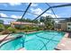 Inviting screened-in pool with spa, surrounded by lush landscaping and seating, perfect for relaxation at 2584 58Th S Ave, St Petersburg, FL 33710
