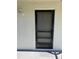 Image of the front door to unit 1512 with a black screen door on a stucco wall at 2625 State Road 590 # 1512, Clearwater, FL 33759