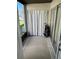 Enclosed lanai space with tiled flooring, curtains and golf clubs at 2625 State Road 590 # 1512, Clearwater, FL 33759