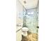 Modern bathroom featuring a glass-enclosed shower with tile accents and wood-look flooring at 27312 Edenfield Dr, Wesley Chapel, FL 33544