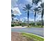 Community clubhouse with palm trees, lush landscaping, and a golf cart, creating a welcoming atmosphere at 27312 Edenfield Dr, Wesley Chapel, FL 33544