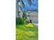 View of the side yard, showcasing green grass and mature landscaping at 27312 Edenfield Dr, Wesley Chapel, FL 33544
