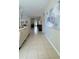 Bright, tiled foyer with neutral walls leads into the open living space, showcasing artwork and natural light at 27312 Edenfield Dr, Wesley Chapel, FL 33544