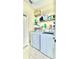 Bright laundry room featuring a washer, a dryer, overhead storage shelves and a door at 27312 Edenfield Dr, Wesley Chapel, FL 33544