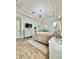 A main bedroom features a trey ceiling, modern light fixture, wood-look flooring, and neutral decor at 27312 Edenfield Dr, Wesley Chapel, FL 33544