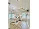Bright bedroom featuring a trey ceiling, modern light fixture, wood-look flooring, and neutral decor at 27312 Edenfield Dr, Wesley Chapel, FL 33544