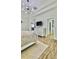 A bedroom features a trey ceiling, modern light fixture, wood-look flooring, and neutral decor at 27312 Edenfield Dr, Wesley Chapel, FL 33544