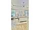 A bedroom features a tray ceiling, modern light fixture, wood-look flooring, and neutral decor at 27312 Edenfield Dr, Wesley Chapel, FL 33544