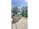 Serene screened patio with comfortable wicker seating, ideal for entertaining and enjoying the outdoors at 27312 Edenfield Dr, Wesley Chapel, FL 33544