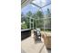 Relaxing screened patio featuring stylish outdoor seating, perfect for enjoying the lush backyard view at 27312 Edenfield Dr, Wesley Chapel, FL 33544