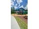 Community playground featuring a covered play structure with slides and picnic tables on a mulched surface at 27312 Edenfield Dr, Wesley Chapel, FL 33544