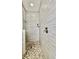 The shower features gray linear tile, pebble floor, and sleek chrome fixtures at 27312 Edenfield Dr, Wesley Chapel, FL 33544