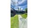 Community tennis courts accessible by a walkway, surrounded by green grass and mature trees at 27312 Edenfield Dr, Wesley Chapel, FL 33544