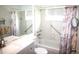 This well-lit bathroom offers a tiled tub and shower combination, grab bars, and updated vanity at 402 Dorchester Pl # 44, Sun City Center, FL 33573