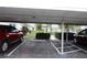 Assigned carport parking with well-manicured landscaping, mature trees, and community at 402 Dorchester Pl # 44, Sun City Center, FL 33573