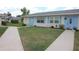 Well-maintained single-story home featuring a light blue front door and lush green lawn at 402 Dorchester Pl # 44, Sun City Center, FL 33573