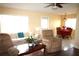 Bright living room with an open concept, a ceiling fan, and a view to the dining room at 402 Dorchester Pl # 44, Sun City Center, FL 33573