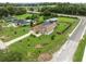 Home with screened pool, complemented by lush landscaping and a long driveway at 40449 Trotter Ln, Dade City, FL 33525
