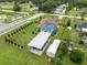 Aerial view of a charming home with a screened pool, a carport, and a well-maintained landscaped yard at 40449 Trotter Ln, Dade City, FL 33525