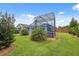 Beautiful backyard with tropical landscaping and screened-in patio off house's rear at 40449 Trotter Ln, Dade City, FL 33525