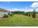 Expansive green backyard with mature landscaping and a charming home exterior at 40449 Trotter Ln, Dade City, FL 33525