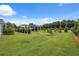 Spacious backyard featuring mature trees, green lawn, and a covered parking structure at 40449 Trotter Ln, Dade City, FL 33525