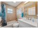 This bathroom is complete with a shower and tub, updated vanity with sink, and updated mirror at 40449 Trotter Ln, Dade City, FL 33525