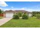 Well-maintained single-story house with a two-car garage and a lush green lawn at 40449 Trotter Ln, Dade City, FL 33525