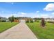 Beautifully landscaped front yard features lush grass, mature trees, and a long driveway at 40449 Trotter Ln, Dade City, FL 33525