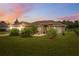 Charming single-story home with a well-manicured lawn and mature landscaping under a lovely sunset at 40449 Trotter Ln, Dade City, FL 33525