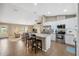 Open kitchen with stainless steel appliances, an island with bar stool seating and view of the living room at 40449 Trotter Ln, Dade City, FL 33525