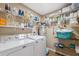 This laundry room features a washer and dryer, multiple shelves, and room for storing cleaning supplies at 40449 Trotter Ln, Dade City, FL 33525