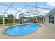A refreshing in-ground pool with screened enclosure offering a delightful outdoor experience on a sunny day at 40449 Trotter Ln, Dade City, FL 33525