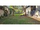 A view of the backyard showcasing the landscaping, mature trees, and grill at 4215 E Bay Dr # 1506C, Clearwater, FL 33764