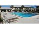 Community pool with lounge seating and several residents enjoying the water at 4215 E Bay Dr # 1506C, Clearwater, FL 33764