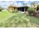 Exterior view of the home and backyard featuring a screened-in porch and a picket fence at 4306 Woodside Manor Dr, Tampa, FL 33624