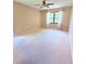 Spacious carpeted bedroom with a ceiling fan and a large window allowing natural light at 4306 Woodside Manor Dr, Tampa, FL 33624