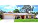 Charming single-story home with a well-manicured lawn and attached two-car garage at 4306 Woodside Manor Dr, Tampa, FL 33624