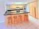 Kitchen island with seating for four, adjacent to modern appliances and light-colored cabinetry at 4306 Woodside Manor Dr, Tampa, FL 33624