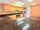 Modern kitchen with granite countertops, stainless steel appliances and light wood cabinets at 4306 Woodside Manor Dr, Tampa, FL 33624