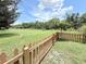 Expansive lawn with a classic picket fence, providing a picturesque backyard setting at 4306 Woodside Manor Dr, Tampa, FL 33624