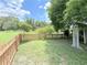 Spacious backyard featuring a manicured lawn and bordered by a classic picket fence at 4306 Woodside Manor Dr, Tampa, FL 33624