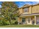 Charming two-story townhome with tan siding, complemented by a well-manicured lawn and a mature tree at 4703 Somerset Hill Ln, Riverview, FL 33578
